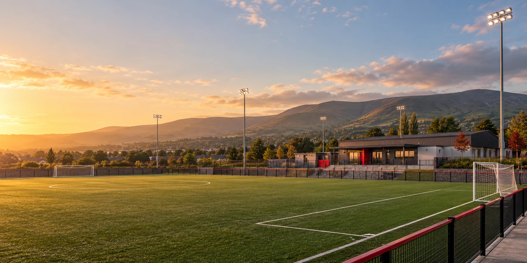 Sacred Heart FC crest over a Tallaght football ground with the Dublin Mountains beyond